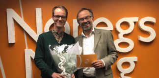 Åsmund H. Eikenes fekk stipendet av Magne Aasbrenn, leiar i Noregs Mållag. Foto: Noregs Mållag